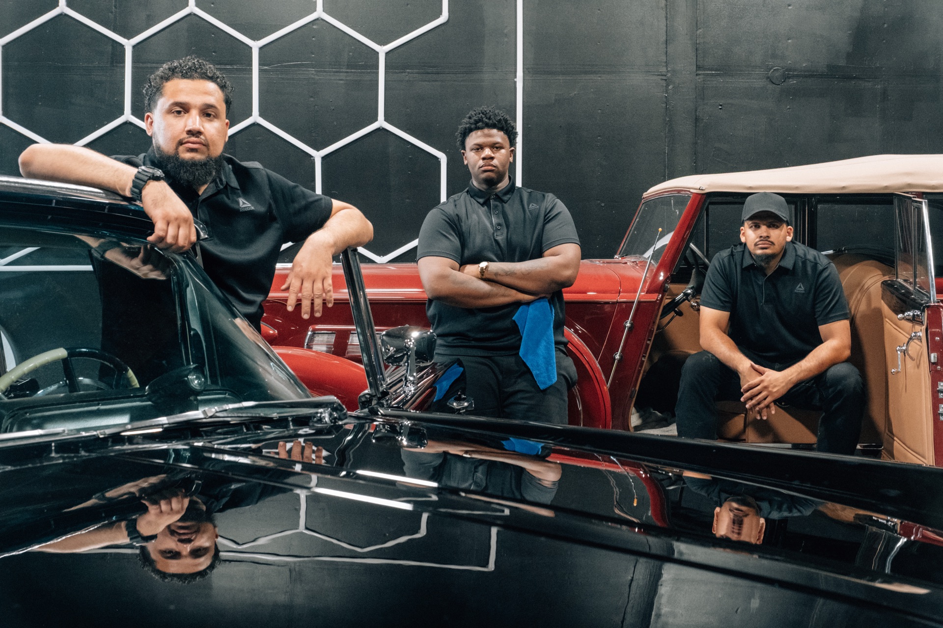 Moody's Extreme Detailing crew inside a hex pattern garage with classic cars